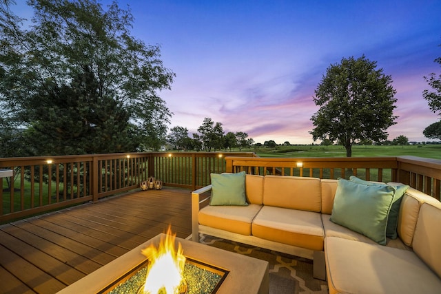 deck at dusk featuring an outdoor living space with a fire pit