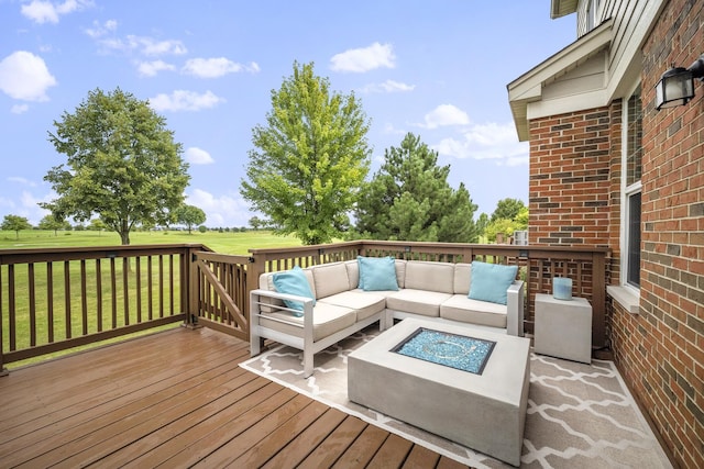 wooden deck with an outdoor living space with a fire pit and a yard