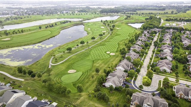 drone / aerial view with view of golf course and a water view