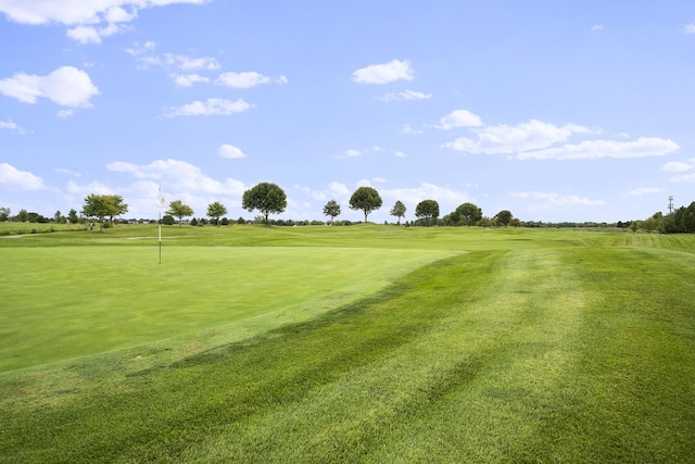 view of property's community featuring a lawn and view of golf course