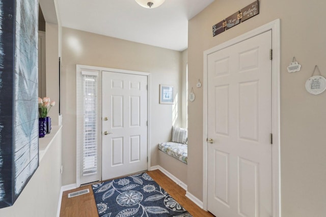 entrance foyer with visible vents, baseboards, and wood finished floors