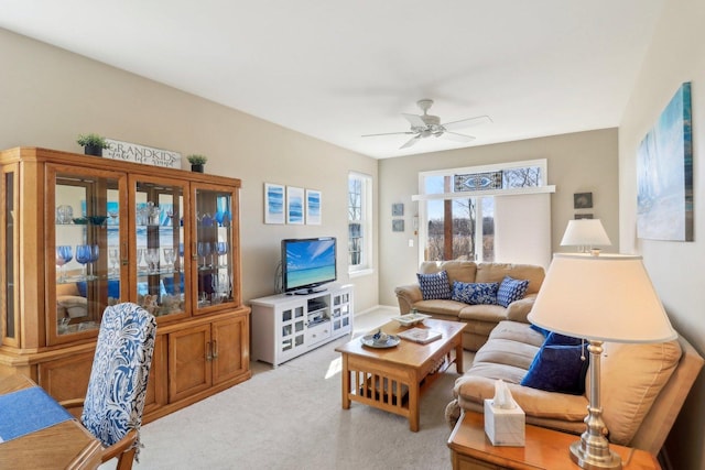 living area featuring light colored carpet and ceiling fan