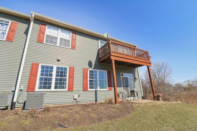 rear view of house featuring a balcony and central AC