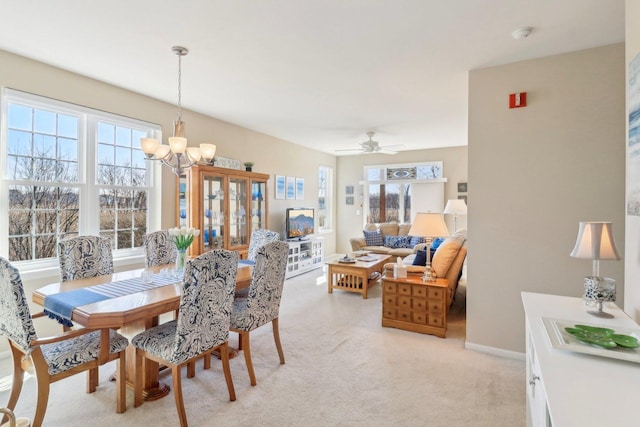 dining room with an inviting chandelier, light colored carpet, and baseboards