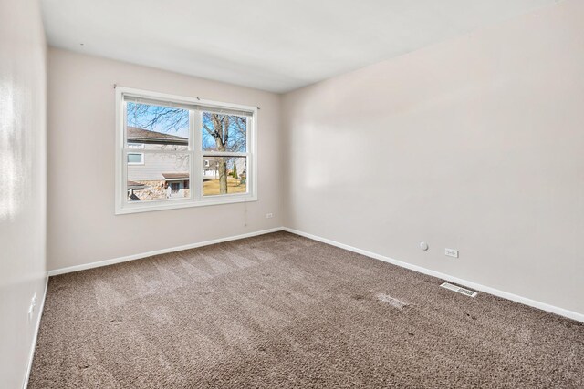 carpeted empty room featuring visible vents and baseboards