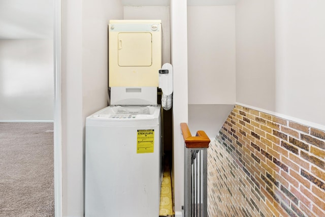 laundry room with laundry area, carpet, and stacked washer and dryer