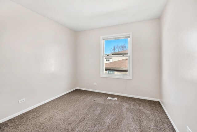 carpeted empty room with visible vents and baseboards