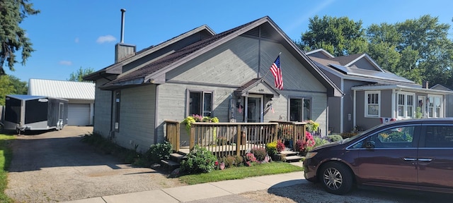 view of front facade with a garage, an outdoor structure, and a chimney