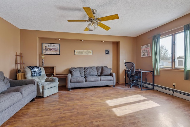 living area with ceiling fan, wood finished floors, a baseboard heating unit, and a textured ceiling