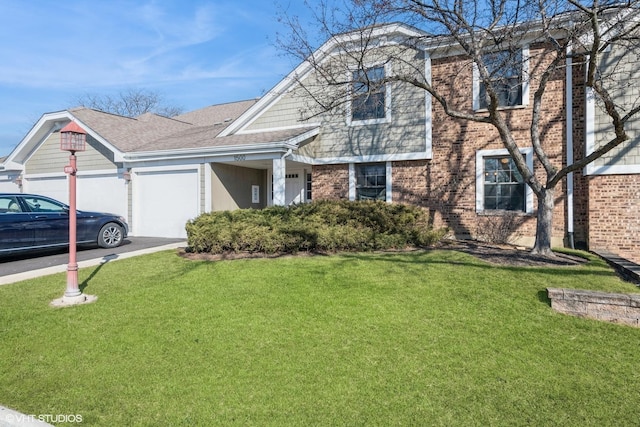 view of front of property with brick siding, driveway, a front yard, and a garage