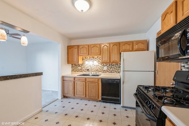 kitchen with tasteful backsplash, black appliances, light countertops, and a sink