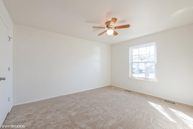 empty room with visible vents, light carpet, and ceiling fan