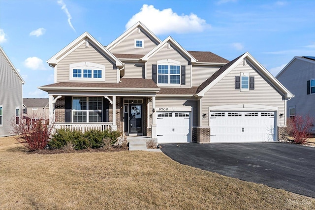 view of front of house featuring a front lawn, driveway, a porch, a garage, and brick siding