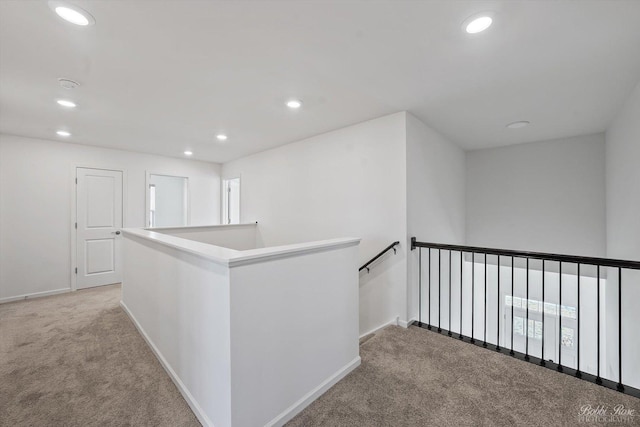 hallway featuring an upstairs landing, recessed lighting, light colored carpet, and baseboards