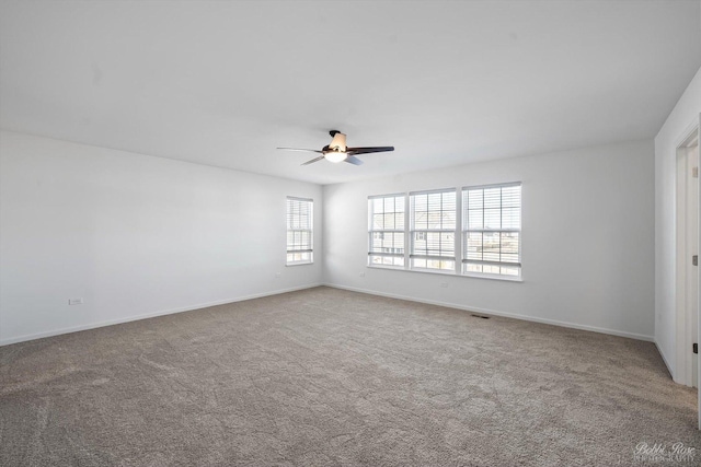 spare room featuring a ceiling fan, baseboards, and carpet floors