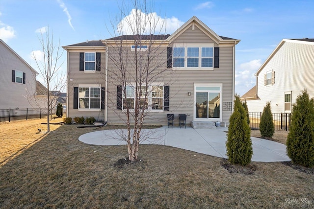 rear view of house featuring fence, a lawn, and a patio area