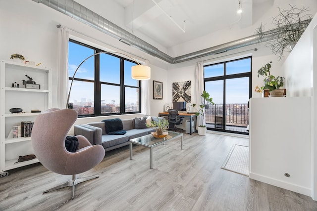 living room with a high ceiling and wood finished floors