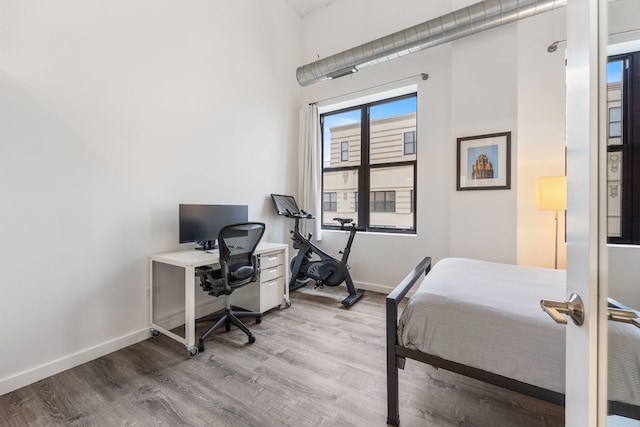 bedroom with baseboards and wood finished floors