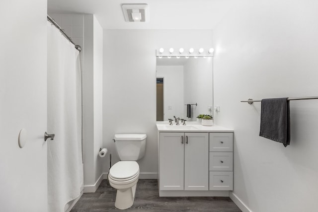 bathroom featuring a shower with curtain, toilet, wood finished floors, baseboards, and vanity