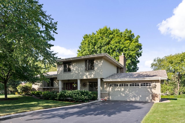 view of front of house with aphalt driveway, a front lawn, brick siding, and an attached garage