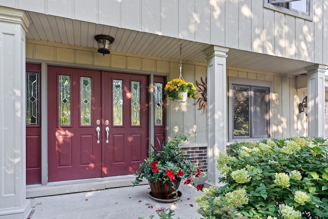 view of exterior entry featuring covered porch and board and batten siding