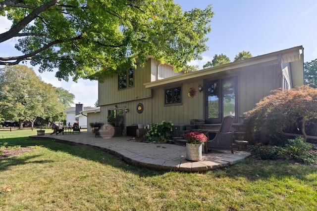 rear view of house featuring a yard and a patio