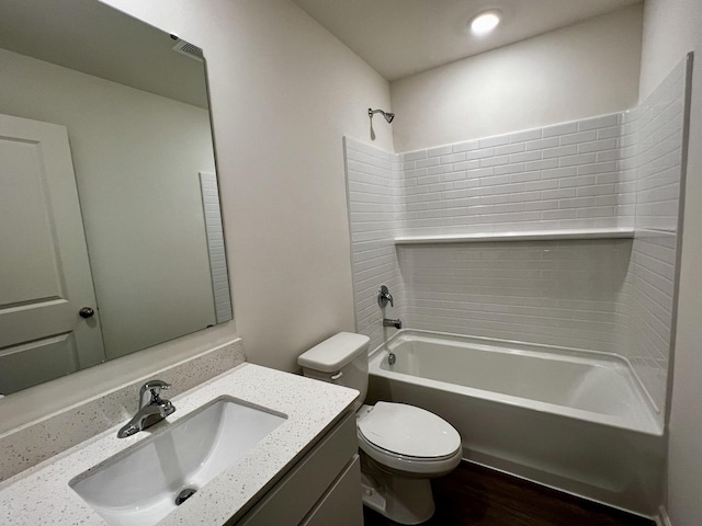 full bath with bathing tub / shower combination, wood finished floors, vanity, and toilet