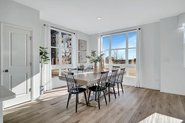 dining space with baseboards and wood finished floors