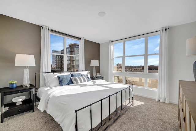 bedroom featuring light carpet and baseboards