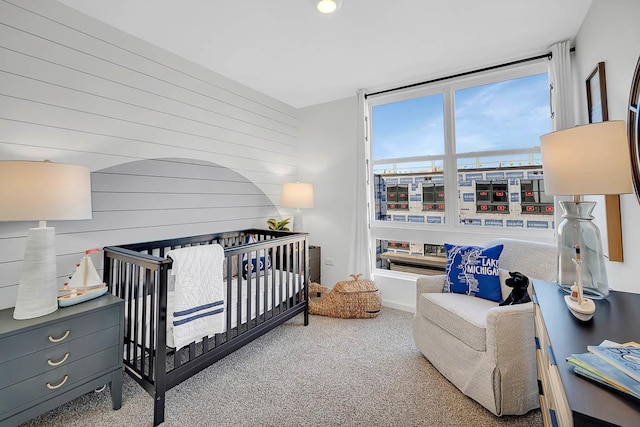 carpeted bedroom featuring a crib