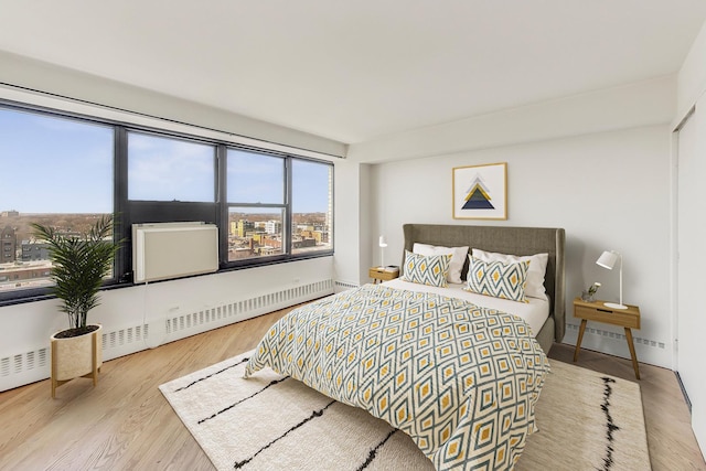 bedroom featuring baseboards, baseboard heating, and wood finished floors