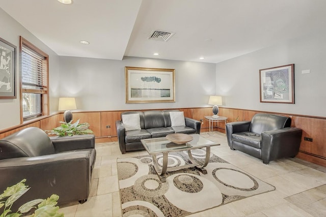 living area featuring a wainscoted wall, wooden walls, recessed lighting, and visible vents