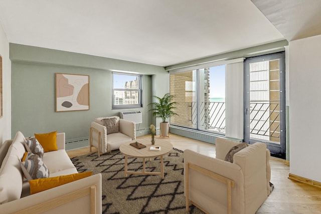 living area with a baseboard heating unit, a healthy amount of sunlight, and a wall mounted air conditioner