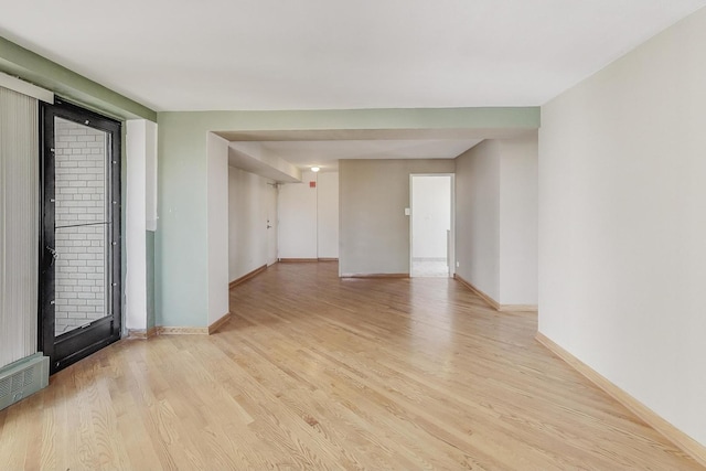 spare room featuring light wood-type flooring, baseboards, and visible vents