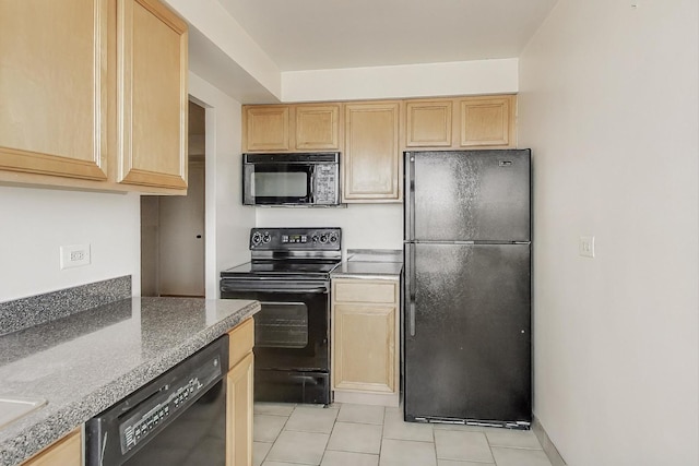 kitchen featuring light brown cabinetry, light tile patterned floors, stone countertops, and black appliances