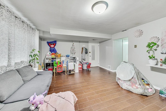 recreation room featuring visible vents, baseboards, and wood finished floors