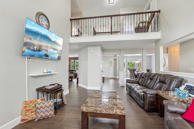 living room featuring a high ceiling, wood finished floors, baseboards, and a wealth of natural light