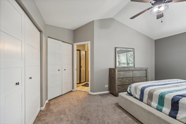 carpeted bedroom featuring two closets, lofted ceiling, a ceiling fan, connected bathroom, and baseboards