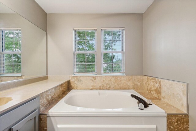 full bath featuring vanity and a garden tub