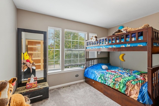 carpeted bedroom with visible vents, multiple windows, and baseboards