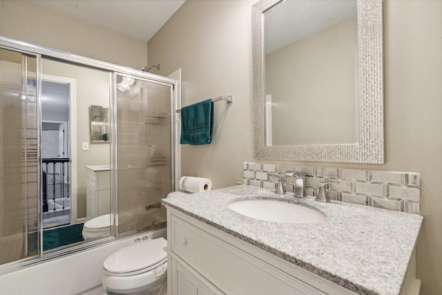 bathroom featuring vanity, toilet, and shower / bath combination with glass door