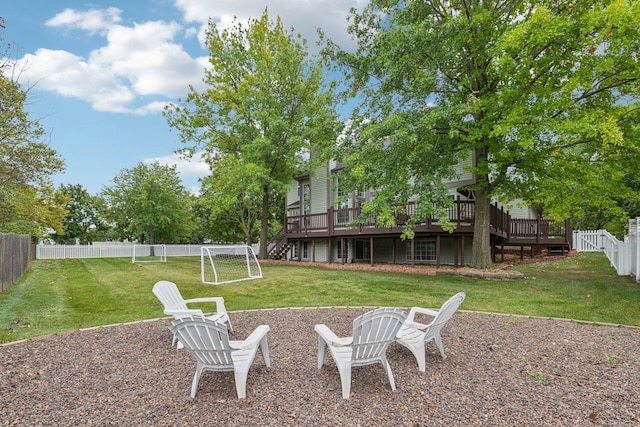 view of yard with a deck, a fire pit, and a fenced backyard