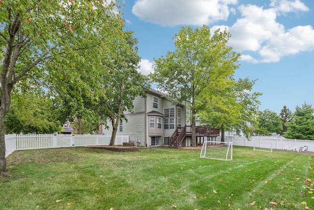 view of yard featuring a deck, a fenced backyard, stairs, and a gate