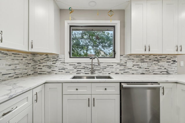 kitchen featuring a sink, backsplash, white cabinetry, and stainless steel dishwasher