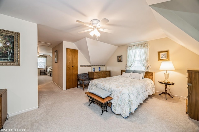 bedroom featuring lofted ceiling, light colored carpet, a closet, and baseboards