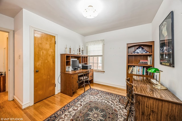 home office with baseboards and wood finished floors