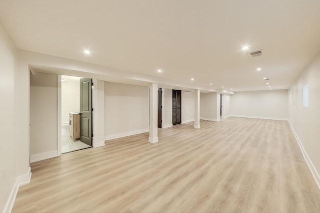 finished below grade area featuring recessed lighting, visible vents, baseboards, and light wood-style floors