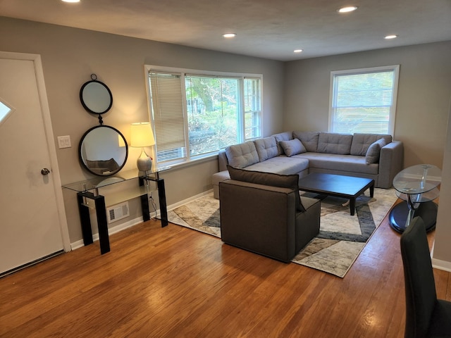 living room featuring recessed lighting, wood finished floors, baseboards, and a wealth of natural light