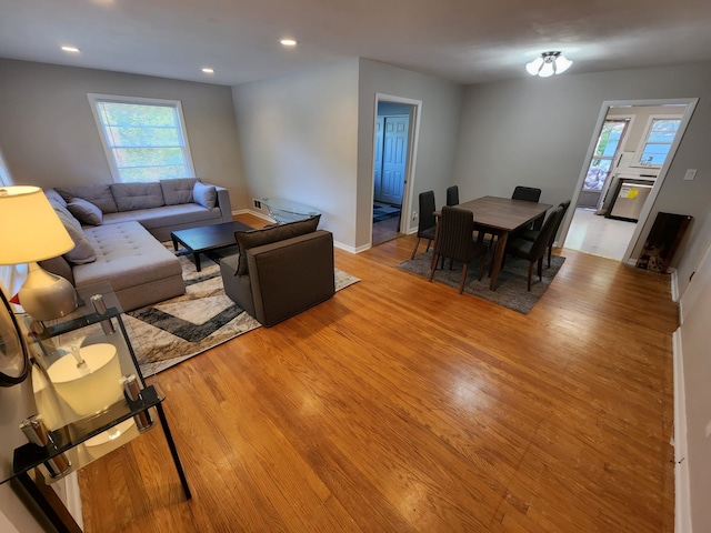 living area featuring recessed lighting, baseboards, and light wood finished floors