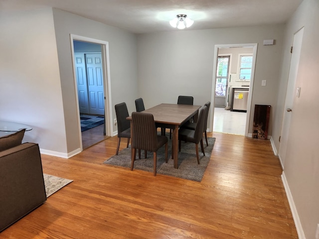 dining space featuring baseboards and light wood finished floors